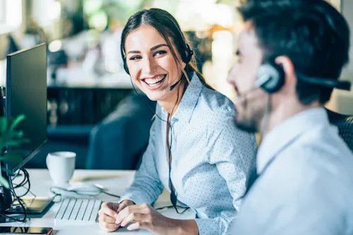 Smiling man and woman in a office providing payroll services.