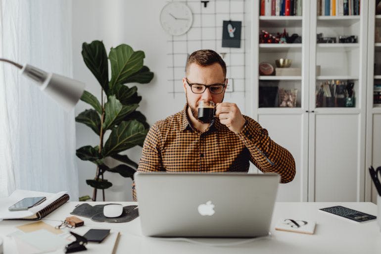 Male business owner using payroll software on a laptop in his office.