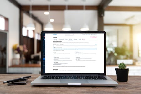 Payroll software for deductions A laptop with BrightHR payroll software that can be used for deductions open on its screen, positioned on a wooden table,