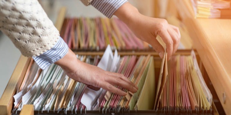 online document storage Person pulling HR documents from a drawer.