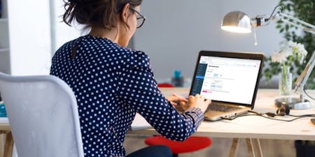 Time tracking software for employees A woman focused at her desk with a laptop, utilising BrightHR