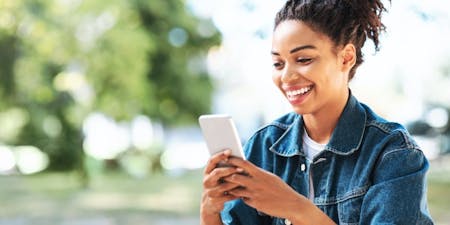 Scheduling app Female business owner smiling using an app to schedule employees.