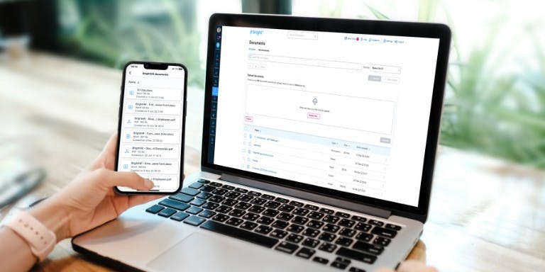 Document management system Phone and laptop on a desk showcasing BrightHR's document management system and cloud-based storage.
