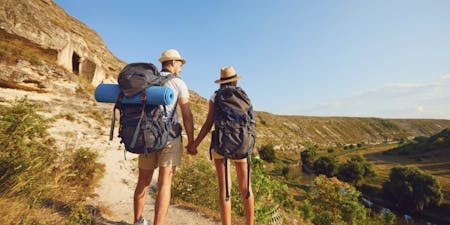 Annual Leave Two individuals with backpacks hiking along a scenic trail, enjoying their annual leave in nature.