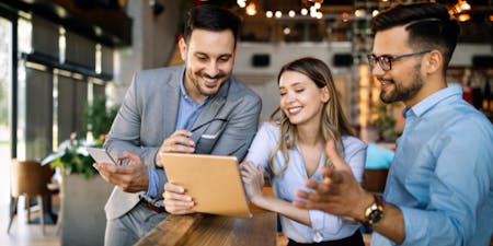 Pay and benefits in Australia Three business individuals analysing data on a tablet, focusing on pay and benefits in Australia.