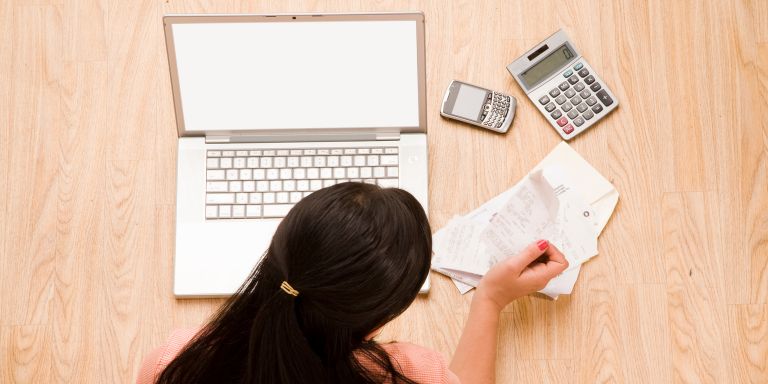A women using laptop and calculators to track hours - should be using time tracking apps
