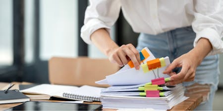 Women organising employee documents on a desk.