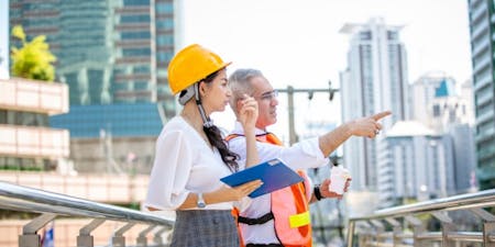 Health and Safety at Work Act Female and male construction supervisor reviewing safety protocols on a bridge, in compliance with Health and Safety standards.