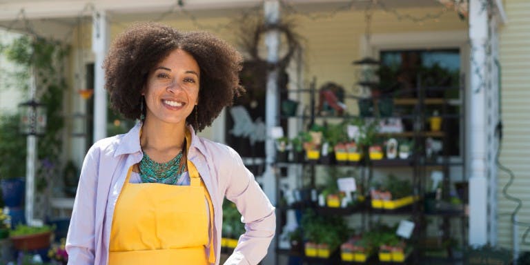 Small business owner stands in front of her flower shop.