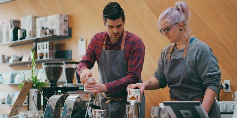 Manager training employee in coffee shop
