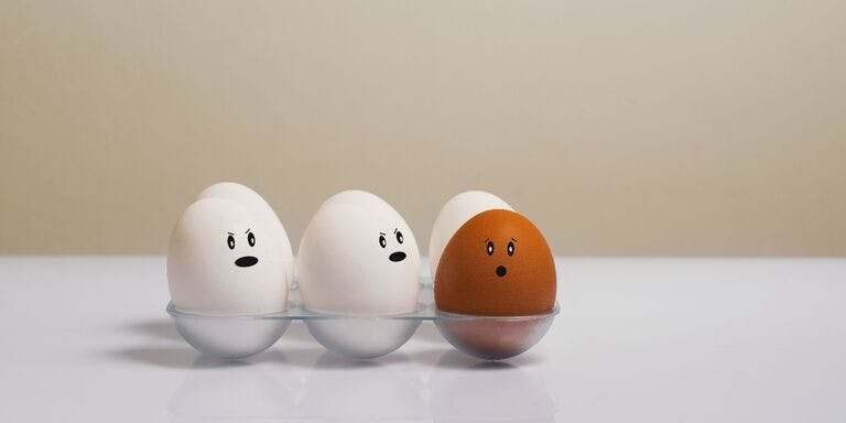 Discrimination at work Five eggs with faces in a glass, symbolising individuality and the need to address discrimination in the workplace.