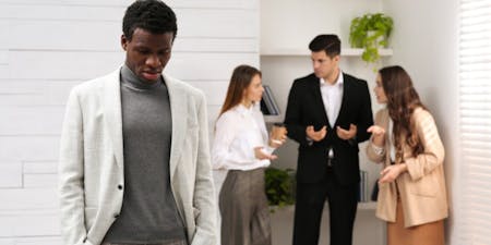 Workplace direct discrimination Man stands in front of a group, representing the challenges of direct discrimination in a work context.
