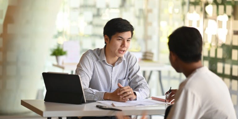 Employee discipline Male employer disciplining an employee in an meeting room.