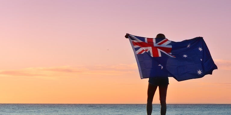 The Australian flag displayed on a beach, representing the spirit of public holidays celebrated across the nation.