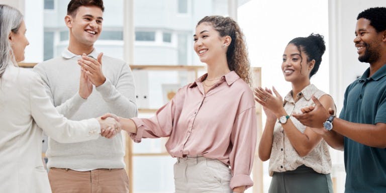 Business owner shaking hands with new hire and successfully onboarding a new employee.