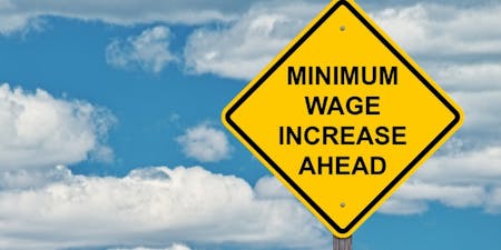 minimum wage increase Australia Graphic illustrating a minimum wage increase is coming with a yellow warning sign.