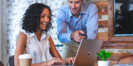 Employee schedule A man and woman collaborate on a laptop, reviewing the employee schedule together in a professional setting.