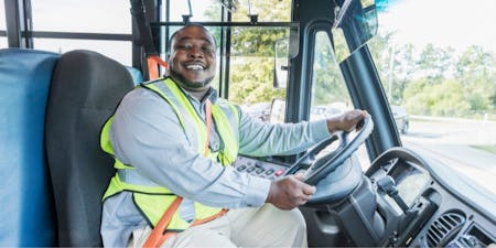 Split shift worker Male bus driving wearing a safety vest in the diver seat of a bus working a split shift.
