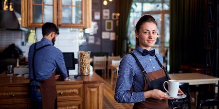 Split shift workers A waitress and waiter working a split shift in a restaurant.