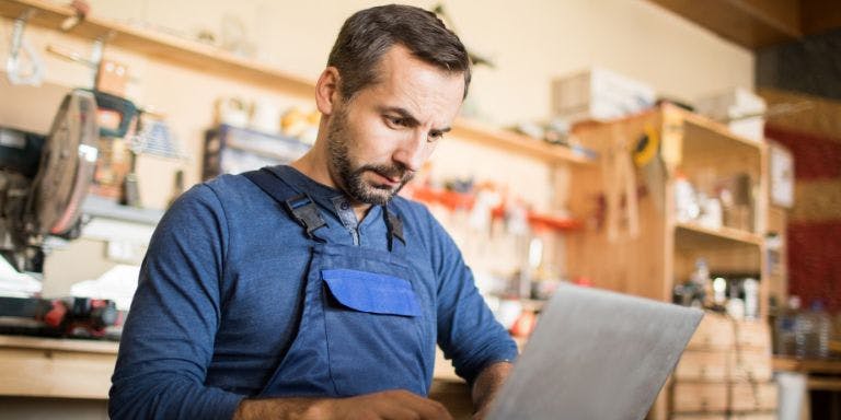 Man on laptop in his small business