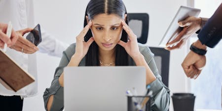 Employee burnout Employee overwhelmed with workload sat at desk