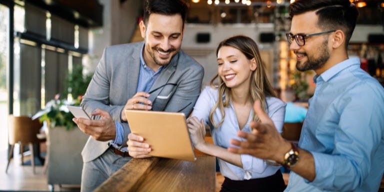 Image of employees viewing a software app on a tablet