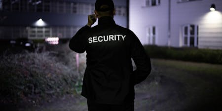 Security guard working at night patrolling a building