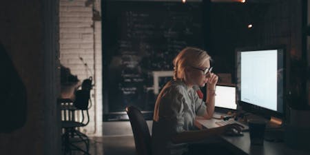 Female worker at a desk on a computer at night time