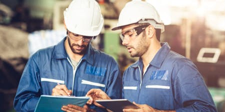 Dress code at work Two employees wearing hard hats and blue overalls