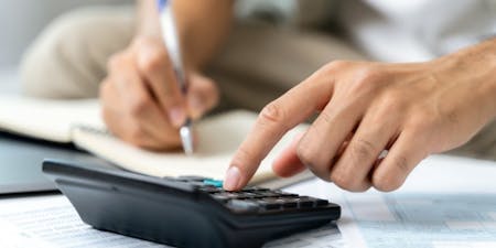 Calculating annual leave entitlements A person using a calculator to complete calculations