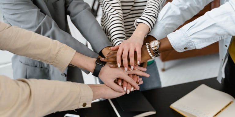 Employees hands in a huddle