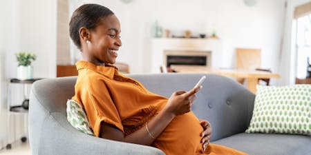 Maternity leave and annual leave leave entitlements Pregnant woman using her phone to book annual leave