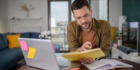 Online training course A man sat at a desk studying with an online training course