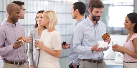 Gossip in the workplace Group of employees chatting and gossiping in a breakroom with drinks and snacks.