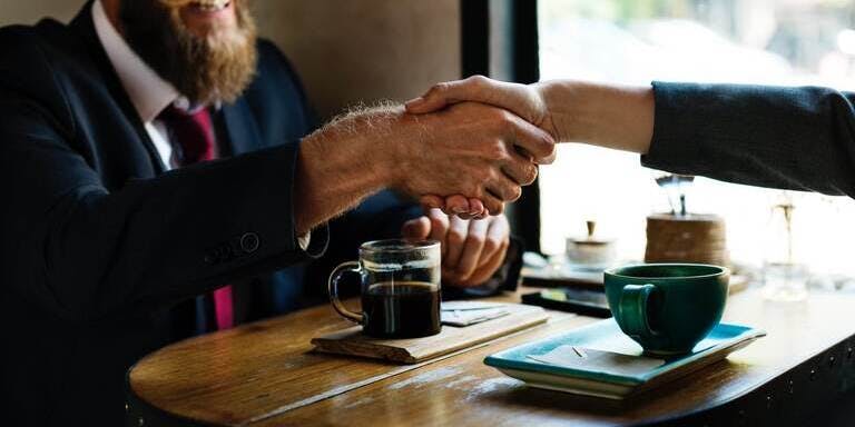 Employee onboarding Two people shaking hands.