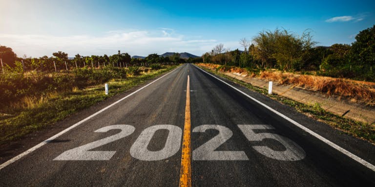A road with "2025" painted on it, leading into the distance