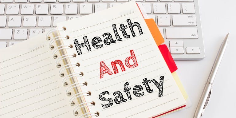 Health and safety training notebook placed next to a computer keyboard