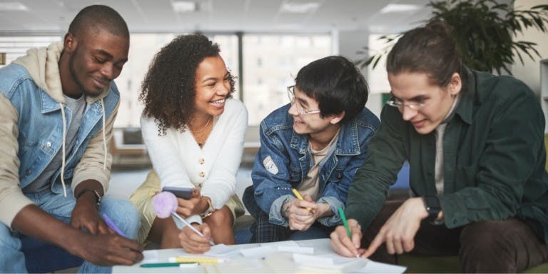Importance of Objective Setting at Work Group of four employees engages in objective setting at a table.