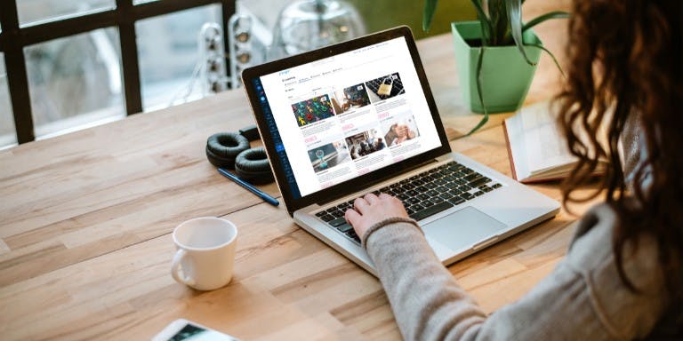 A woman sat at a desk using the BrightSafe learning management system for workplace training