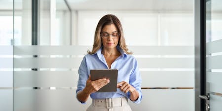 Online training for employers and employees A business owner using a tablet devices to access online training for her workplace