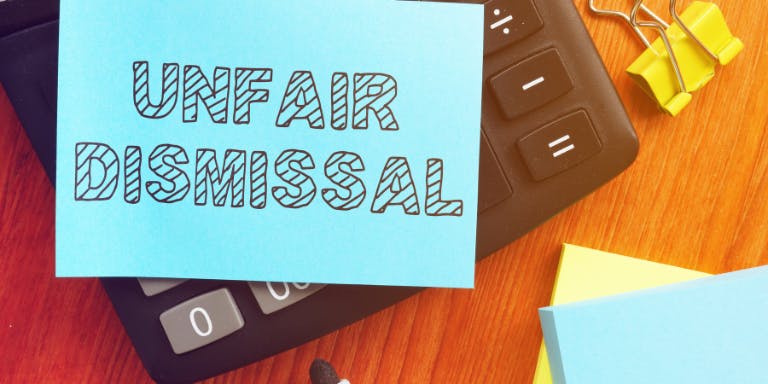 A post-it-note saying "Unfair Dismissal" on a table