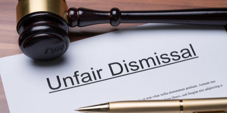 A page with the words "Unfair Dismissal" on it, next to a gavel