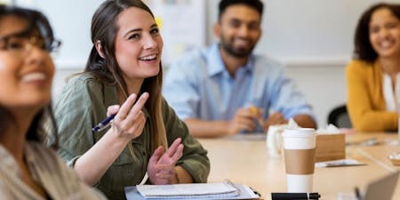 Employees engaging in positive group discussion, happy with their workplace and roles