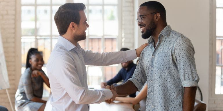 Manager awarding employee with praise for achieving targets
