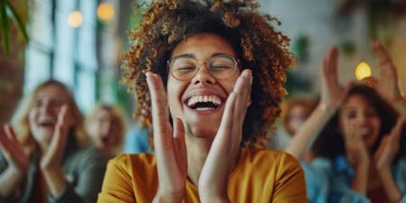 Female employee smiling and clapping celebrating great performance at work.