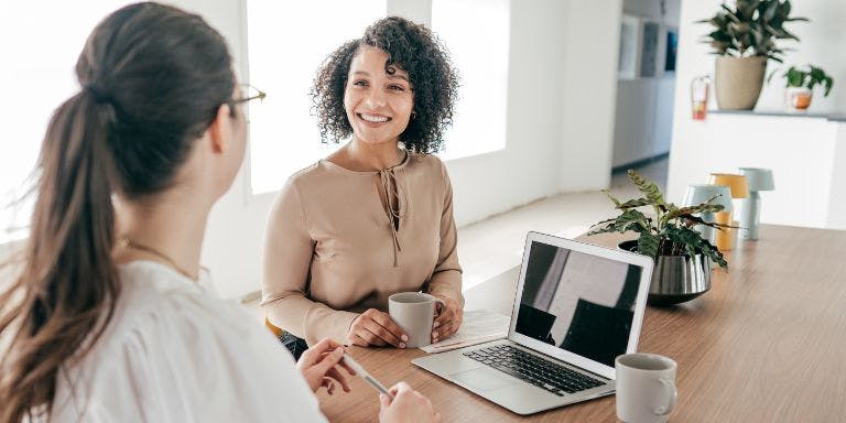 Employer HR compliance A meeting between a manager and employee over coffee
