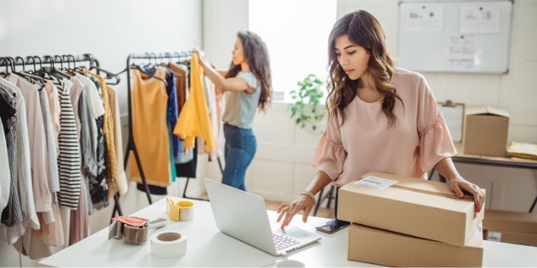 Small business owner on a computer in her clothing shop