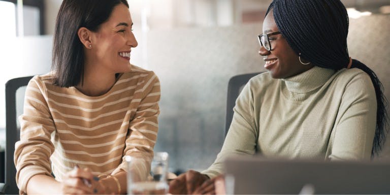Employer and employee at a desk discussing personal development.