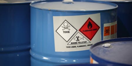 Hazardous substance symbols Multiple barrels featuring labels and signs, including hazardous substance symbols.