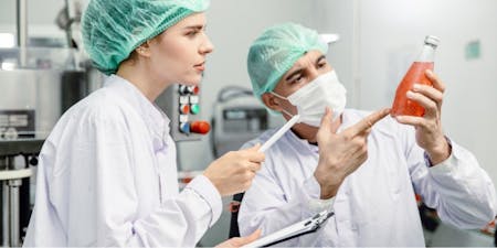 SDS Safety Data Sheet People in a lab checking a safety data sheet for the substance they work with.